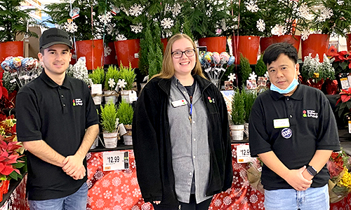 three members in front of a Valentine's day display