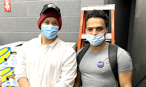 two members standing side by side in a stock room