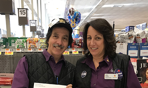 two members standing side by side by cash registers